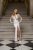 Léna - maxi šaty s dlhým rukávom, matným čipkovaným topom a hlbokým výstrihom do V, úzkou sukňou, v bielej farbe.